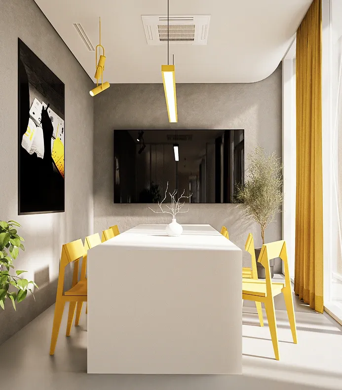 Creative studio-style office with a central yellow worktable, black and white chairs, shelving with books and decor, grey concrete walls, and bright daylight from large windows